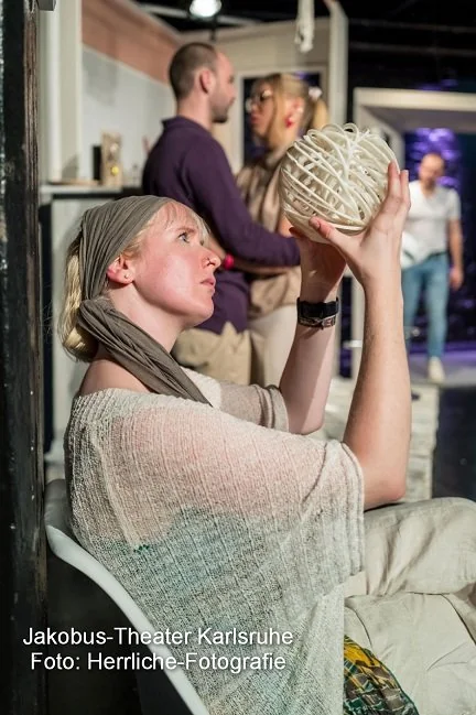 Theaterstück Der Spieleabend Frau betrachtet Kugel Theaterstück Der Spieleabend Frau betrachtet Kugel